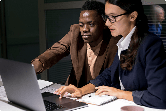 Two engineers reviewing an incident investigation together at a laptop.
